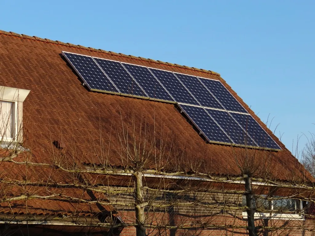Maison en brique dont le toit est couvert de panneaux solaires